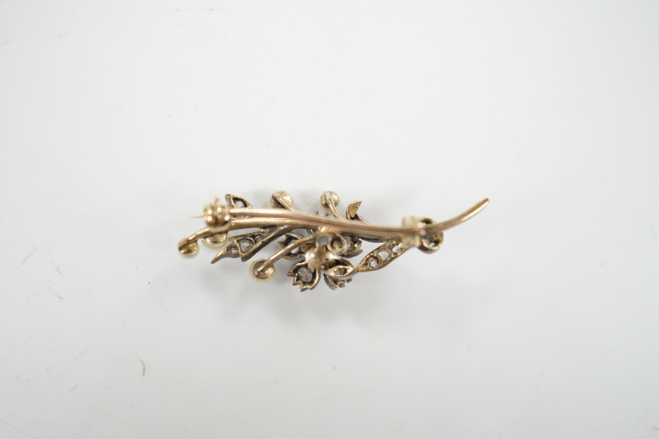 A cased Victorian yellow metal, seed pearl and rose cut diamond set foliate spray brooch, 39mm, gross weight 4.4 grams.